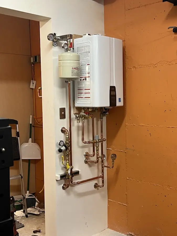 Plumbing technician inspecting water heater connections in Ridgewood village